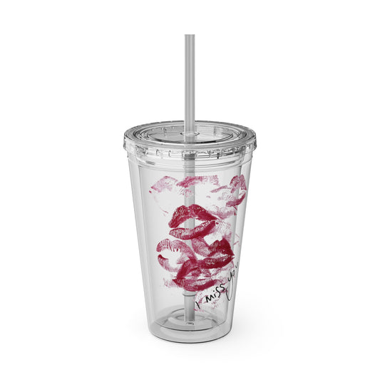 Clear tumbler with red lip prints and a straw on a white background