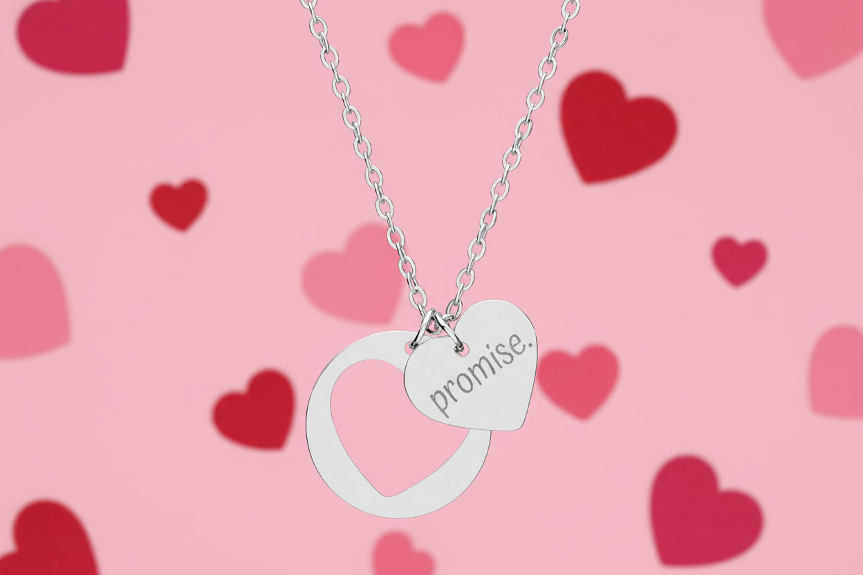 Silver necklace with a heart-shaped pendant engraved with 'promise.' on a white background