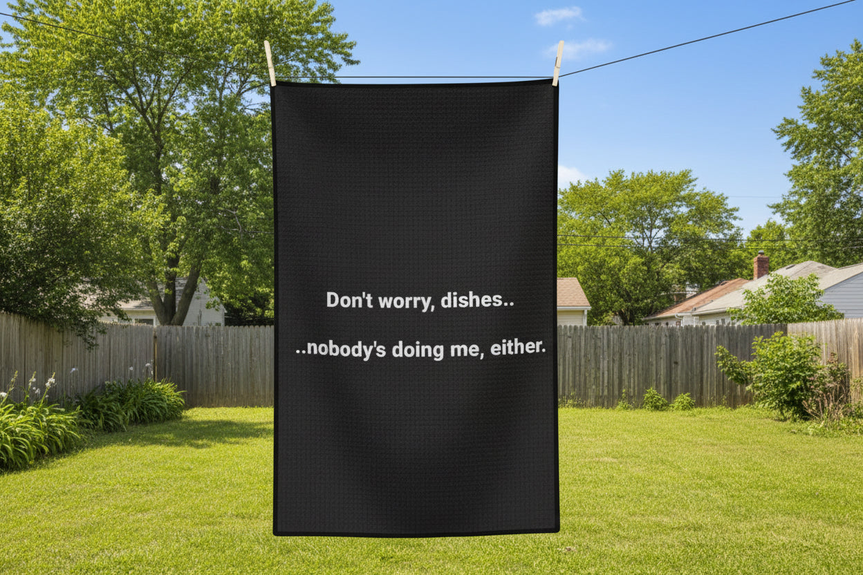 Black towel with white text hanging on a line