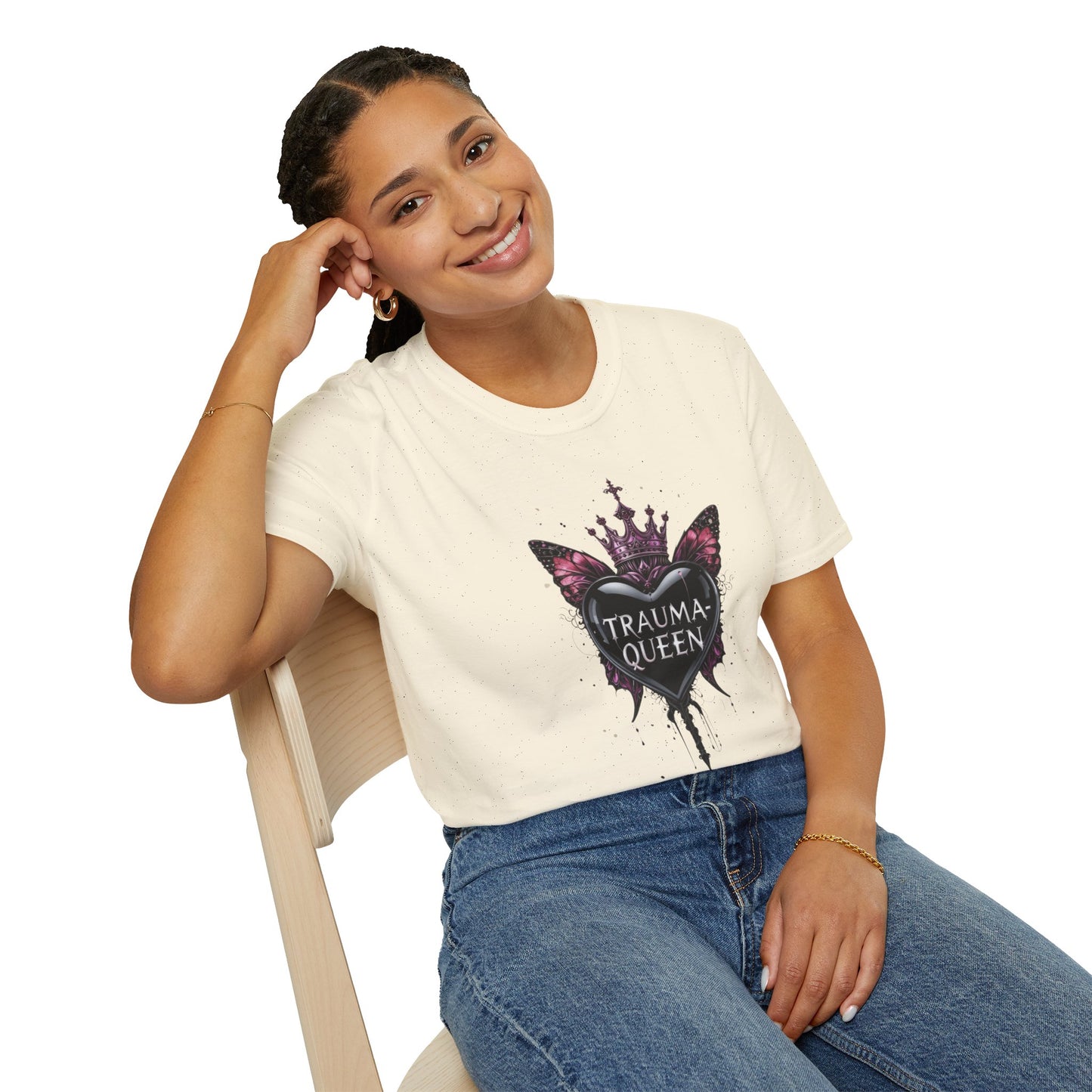 Person wearing a white t-shirt with a graphic design sitting on a chair.