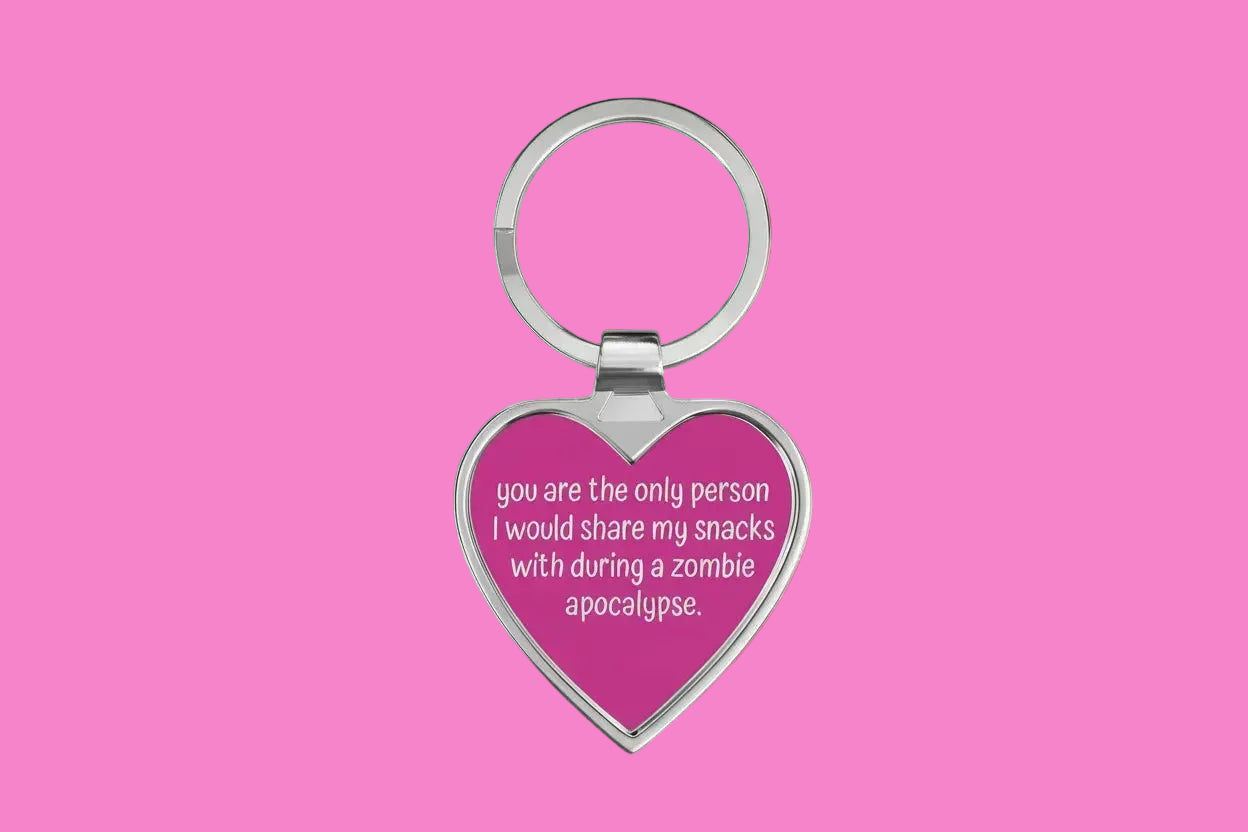 Heart-shaped keychain with humorous text on a pink background