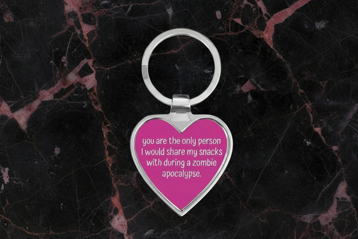 Heart-shaped keychain with humorous text on a dark marbled background